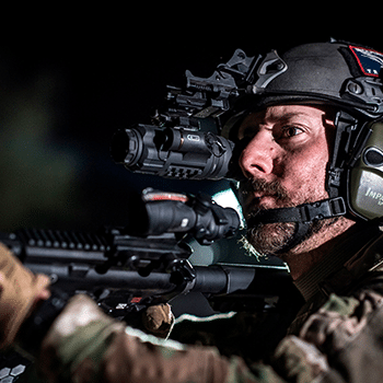 Geared-up solder shown aiming an AR-15 rifle with a Trijicon IR-Patrol thermal monocular mounted to it.