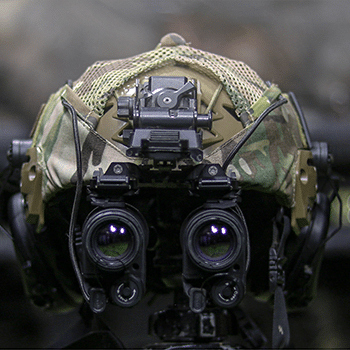 Photo showing a military helmet with the InfiRay Outdoor MINI mounted to it.