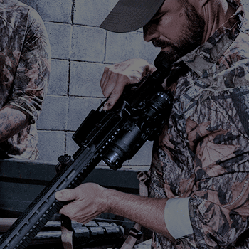 Man shown holding an AR-15 style rifle with a Trijicon IR-HUNTER 2 thermal riflescope attached.